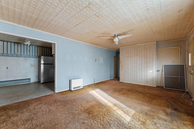 carpeted spare room with heating unit, ornamental molding, ceiling fan, and baseboard heating