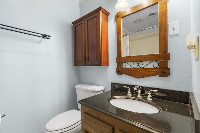 bathroom with vanity, walk in shower, and toilet