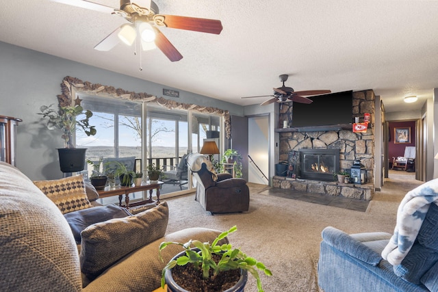 living room featuring a fireplace, carpet floors, a textured ceiling, and ceiling fan