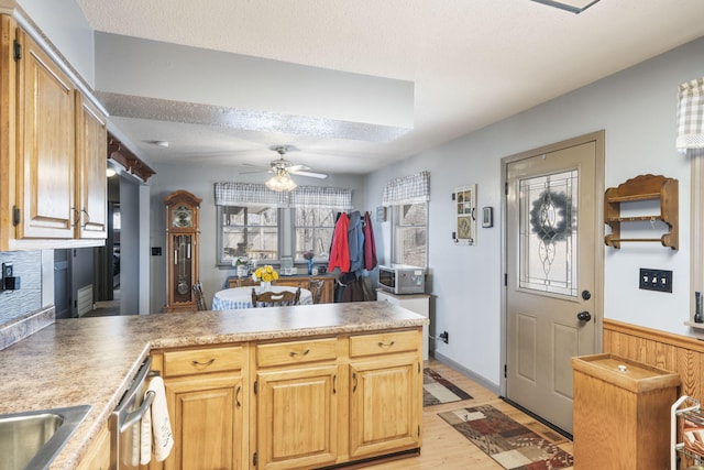 kitchen with ceiling fan, light hardwood / wood-style floors, a textured ceiling, light brown cabinetry, and kitchen peninsula