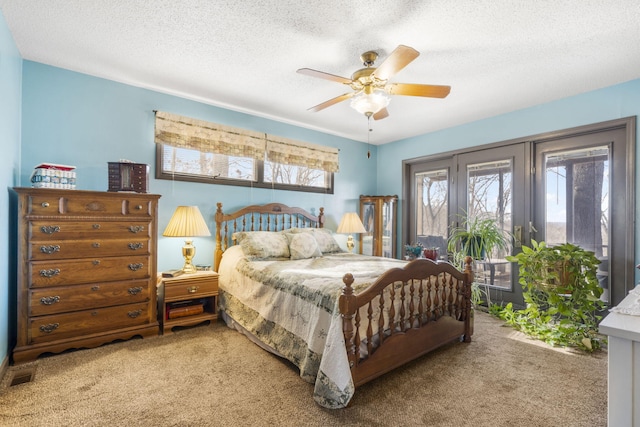 carpeted bedroom featuring a textured ceiling and ceiling fan