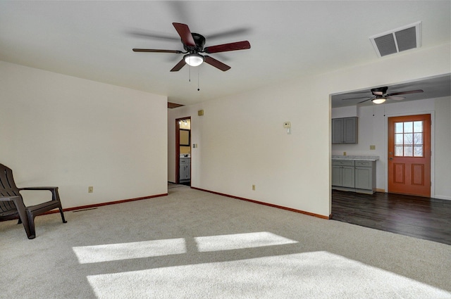 unfurnished living room with dark carpet and ceiling fan