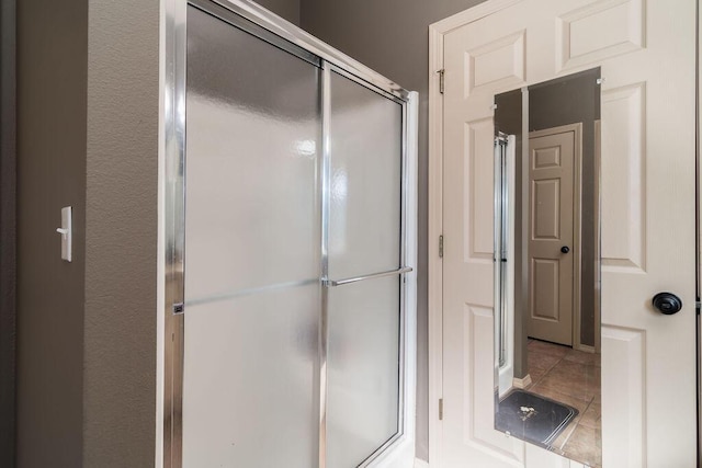 bathroom with tile patterned flooring and a shower with shower door