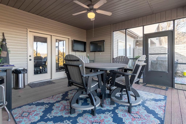 sunroom / solarium featuring a healthy amount of sunlight, wood ceiling, and ceiling fan