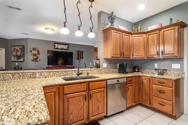 kitchen featuring pendant lighting, dishwasher, sink, light tile patterned floors, and light stone counters