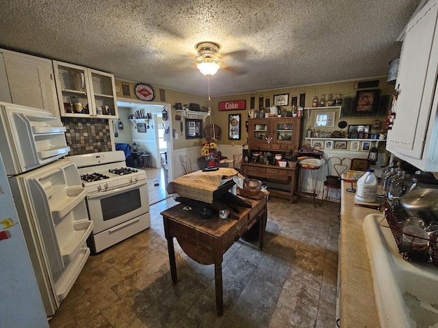 kitchen with white cabinetry, white gas stove, and ceiling fan