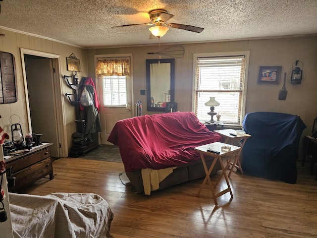 living room with ceiling fan, hardwood / wood-style flooring, plenty of natural light, and a textured ceiling