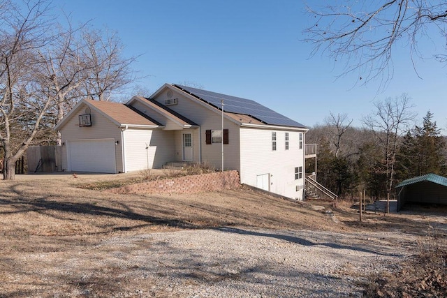 view of side of home with a garage and solar panels