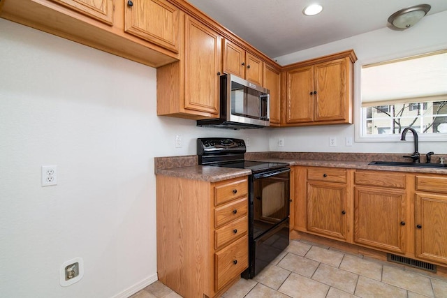 kitchen featuring sink, black electric range, and light tile patterned floors