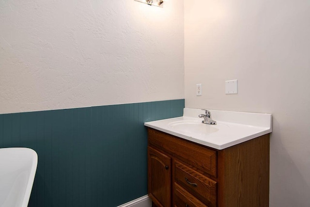 bathroom featuring vanity and wood walls