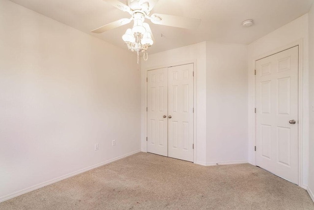 unfurnished bedroom featuring light carpet, a closet, and ceiling fan