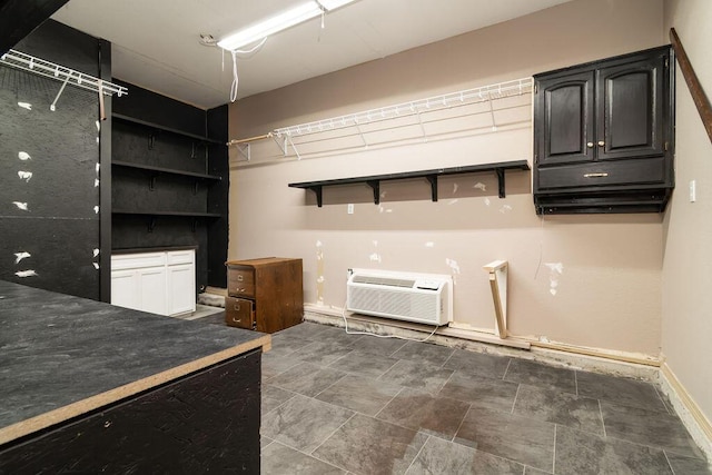 kitchen with white cabinets and a wall mounted AC