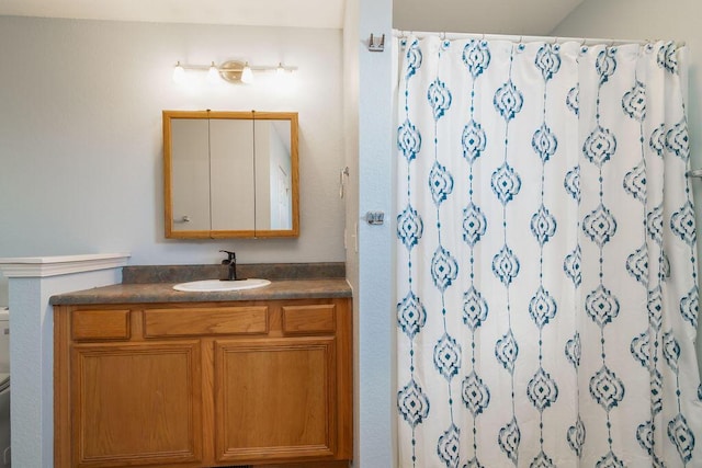 bathroom featuring vanity, toilet, and walk in shower