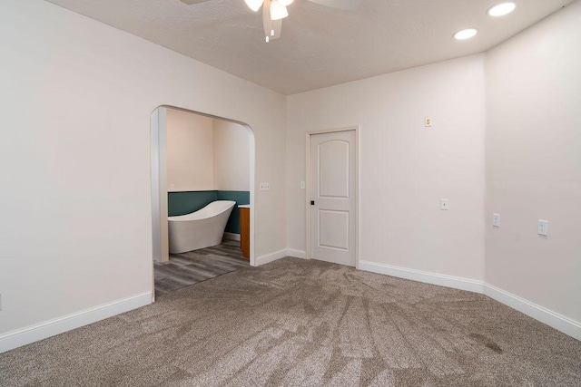 spare room with ceiling fan and carpet