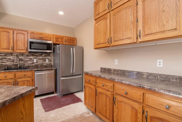 kitchen with tasteful backsplash, appliances with stainless steel finishes, and sink