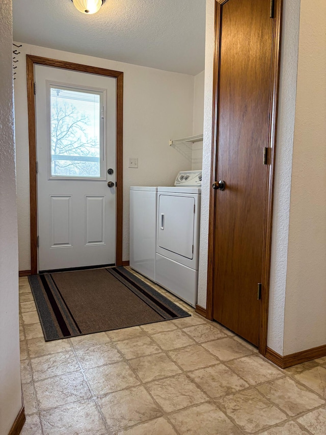 clothes washing area featuring washer and clothes dryer and a textured ceiling