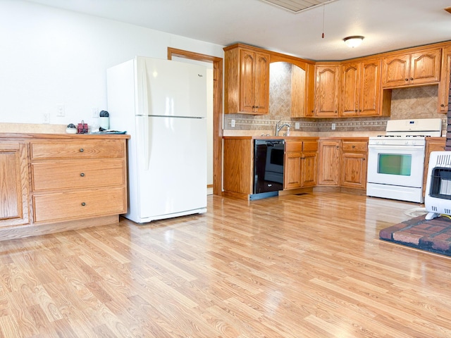 kitchen with sink, backsplash, white appliances, and light hardwood / wood-style flooring