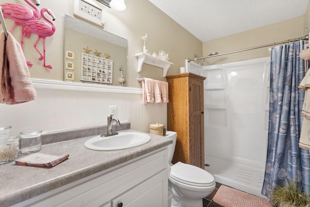 bathroom featuring toilet, a stall shower, vanity, a textured ceiling, and tile patterned floors