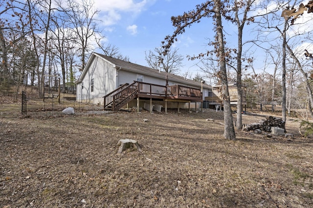 rear view of house featuring a wooden deck and stairs