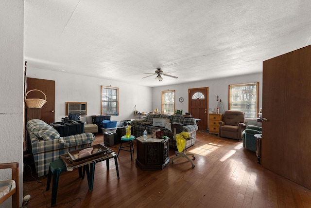 living room featuring ceiling fan, wood-type flooring, and a textured ceiling