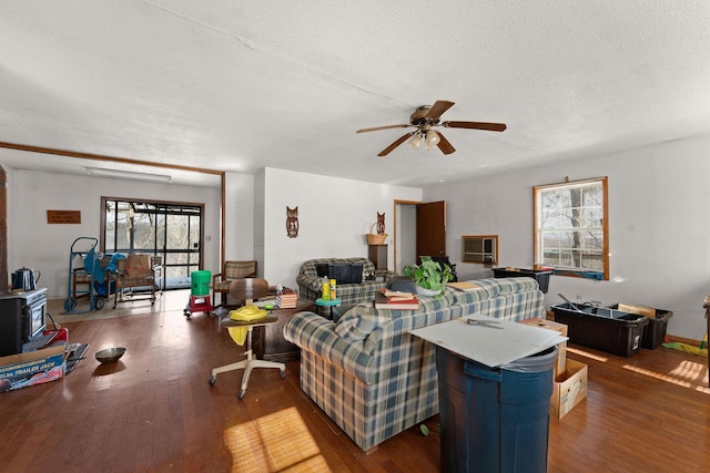 living room with ceiling fan, dark hardwood / wood-style flooring, and a textured ceiling