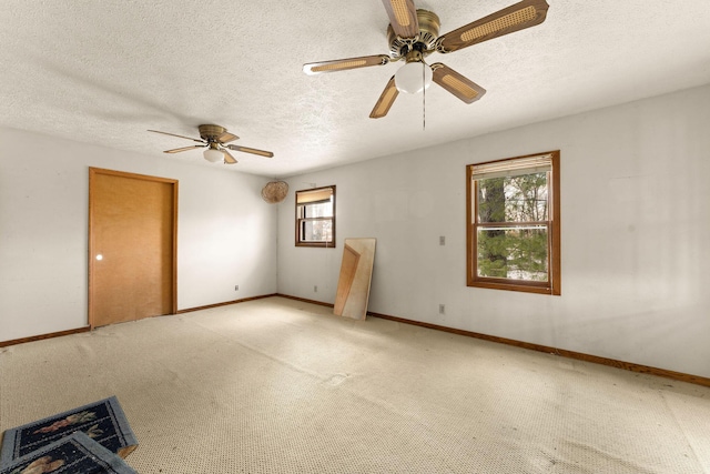 carpeted spare room featuring ceiling fan and a textured ceiling