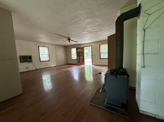 406 Red Bridge Rd, Ozark, MO 65721 - unfurnished living room featuring a wood stove, ceiling fan, wood finished floors, healthy amount of natural light, and a textured ceiling