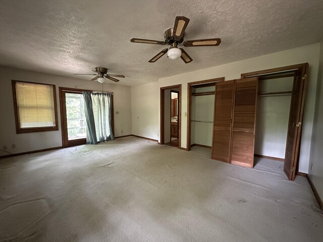 406 Red Bridge Rd, Ozark, MO 65721 - unfurnished bedroom with a textured ceiling, two closets, light carpet, and ceiling fan
