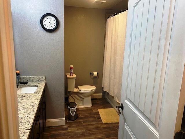 bathroom with vanity, toilet, and hardwood / wood-style floors