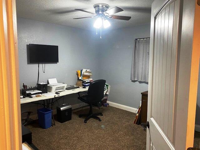 office space featuring ceiling fan, a textured ceiling, and dark colored carpet