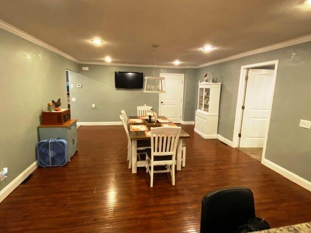 dining room featuring ornamental molding and dark hardwood / wood-style flooring