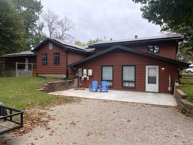 rear view of property featuring a lawn and a patio