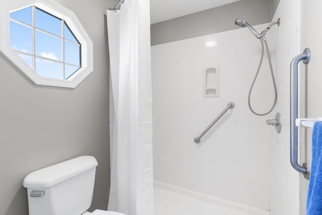 bathroom with a shower with curtain and toilet