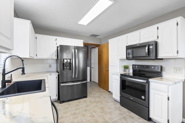 kitchen with white cabinetry, sink, backsplash, electric range, and stainless steel refrigerator with ice dispenser