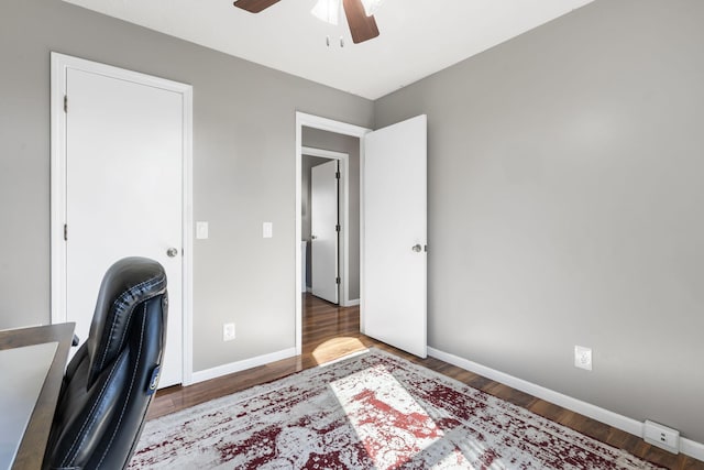 unfurnished office with ceiling fan and wood-type flooring