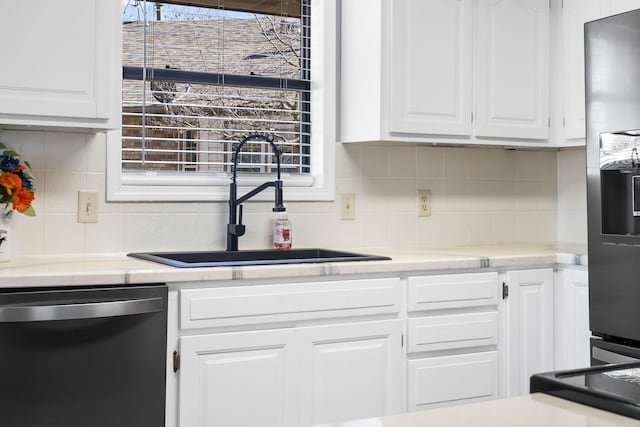 kitchen with sink, refrigerator with ice dispenser, dishwasher, backsplash, and white cabinets