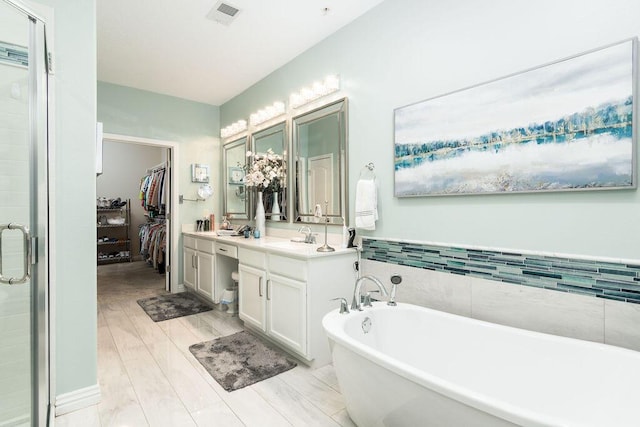 bathroom with vanity, hardwood / wood-style floors, and shower with separate bathtub