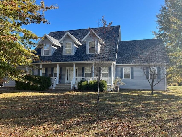 new england style home with a front yard and covered porch