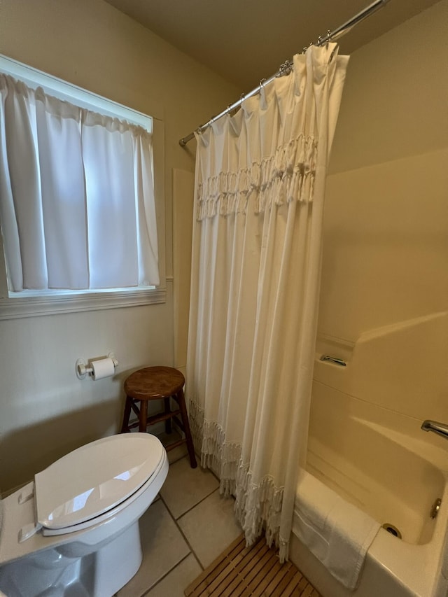 bathroom with tile patterned floors, toilet, and shower / tub combo with curtain