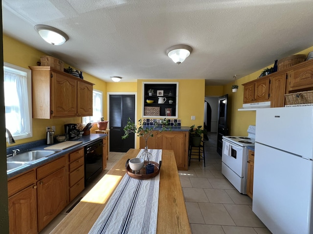 kitchen with a wealth of natural light, white appliances, dark countertops, and arched walkways