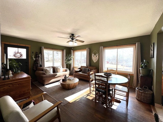 dining space featuring a textured ceiling, a ceiling fan, and wood-type flooring