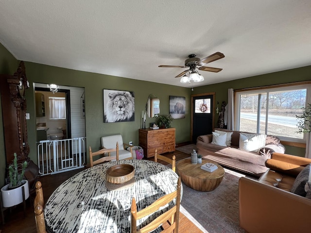 living room featuring a textured ceiling, wood finished floors, and ceiling fan