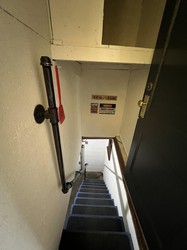 staircase featuring a textured wall