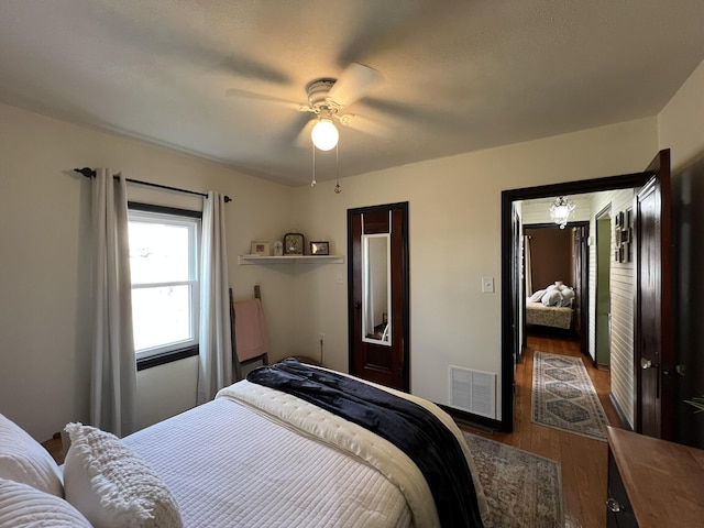 bedroom with visible vents, ceiling fan, and wood finished floors