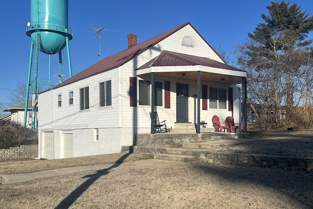 bungalow with metal roof and a chimney