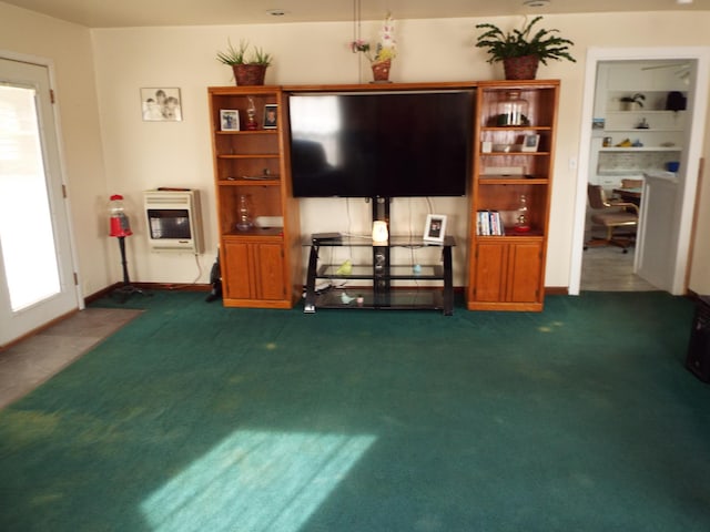 living room with a healthy amount of sunlight, dark carpet, and heating unit