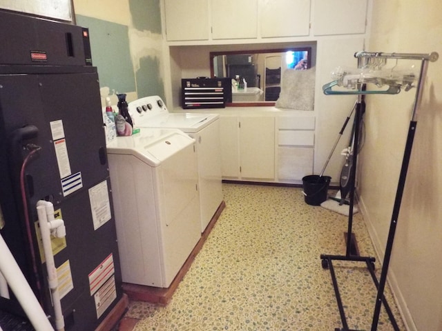 laundry area with cabinets, washer and dryer, and heating unit