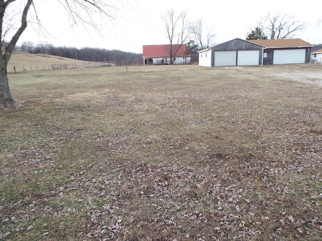 view of yard featuring a garage and a rural view