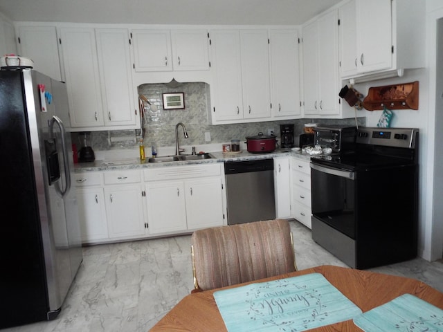 kitchen featuring stainless steel appliances, sink, white cabinets, and decorative backsplash