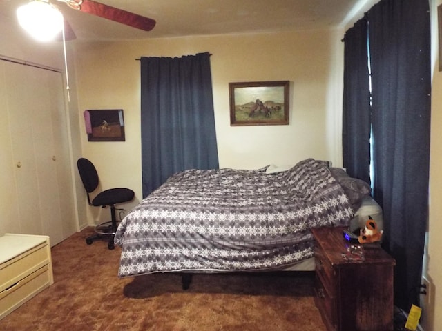 carpeted bedroom with ceiling fan and a closet